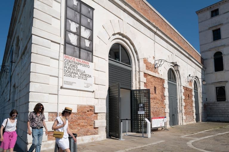Exterior of Punta della Dogana in Venice with a poster for Bruce Nauman's Contrapposto Studies exhibition.